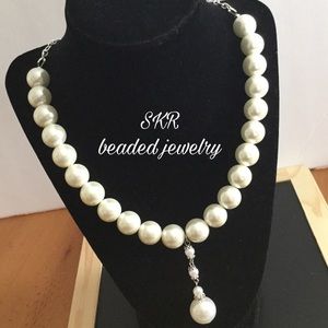 Pearl necklace with enhancer charm.